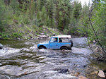 Stuck midstream and being pushed downstream by the current.