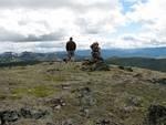 Dave and the pups cringing in the wind towards the other cairn.